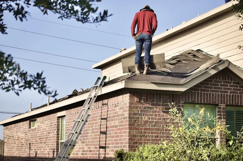 Professional roofer working on a residential roof in Robeson Extension